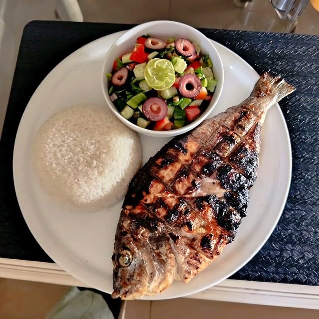 سمكة كاملة مشوية مع الأرز وسلطة طازجة