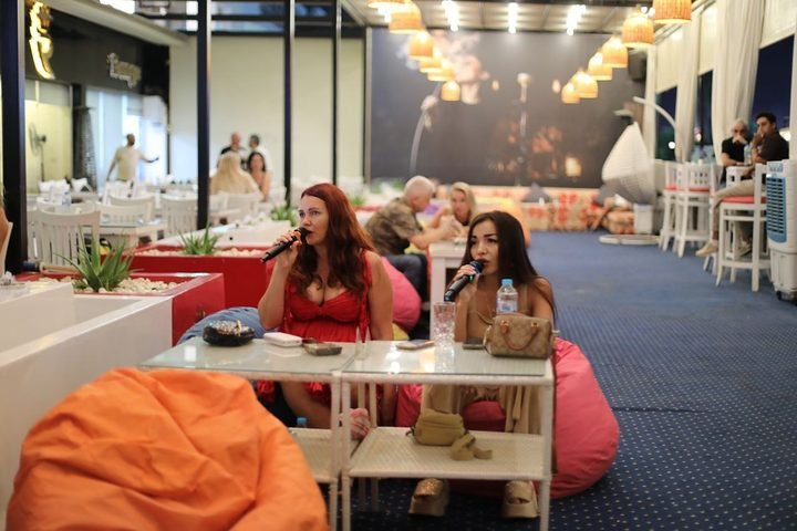 A karaoke duet at a terrace table